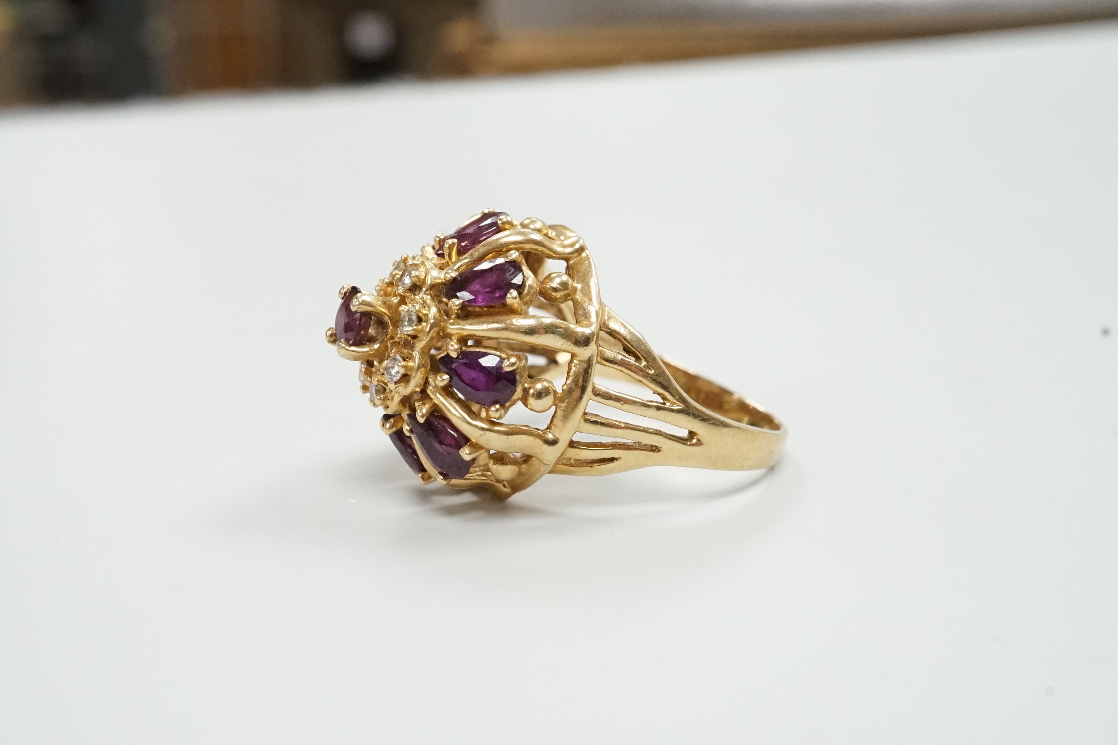 A modern 14ct gold, amethyst? and diamond chip cluster set domed dress ring, size M, gross weight 7.2 grams.